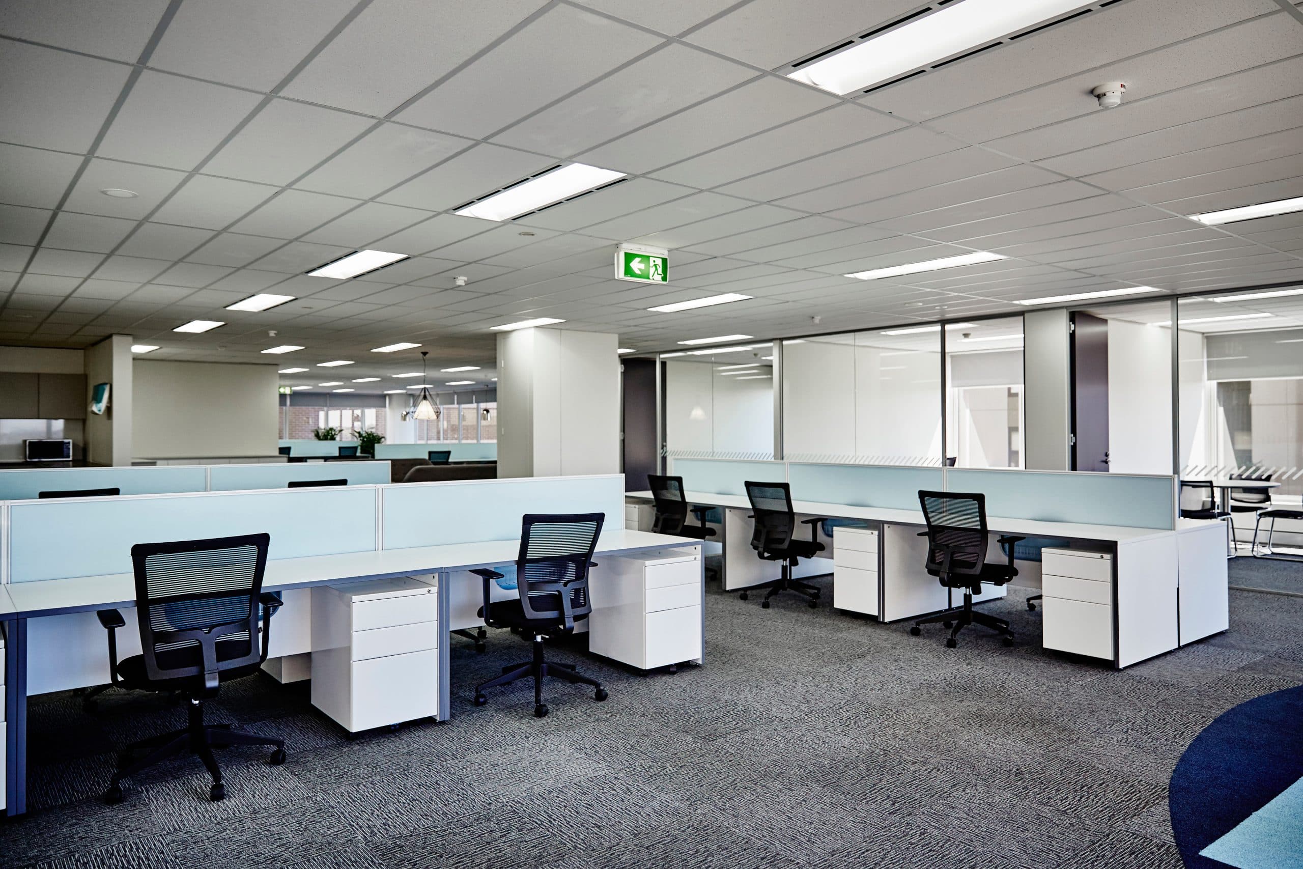 An empty, modern office space is shown, representing the corporate environment of Migdal Insurance.